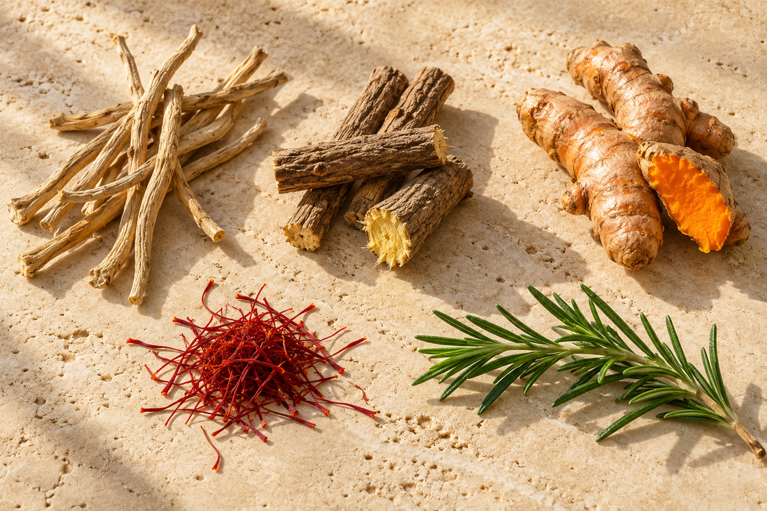 Dried ashwagandha roots, licorice root sticks, fresh turmeric, saffron threads and a sprig of rosemary on a cream stone surface